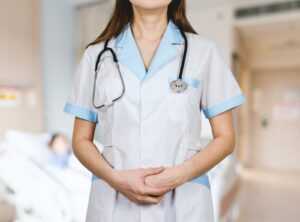 kobieta w białej zapinanej koszuli i niebieskim stetoskopie